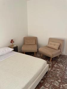 a bedroom with a bed and a chair at Gemma's Apartments in Mazzeo