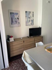 a room with a television on a wooden dresser at Gemma's Apartments in Mazzeo