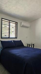 a bedroom with a blue bed and a window at Villa Privada 1200m2 Laguna a Pasos Pet Friendly in Xul-Ha