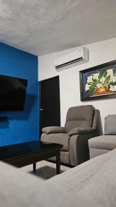 a room with a bed and a couch and a tv at Villa Privada 1200m2 Laguna a Pasos Pet Friendly in Xul-Ha