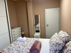 a bedroom with a bed with a dresser and a mirror at Nesti house in Orikum