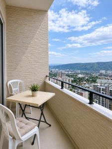 a balcony with a table and chairs and a view at Vazi Aparthotel in Tbilisi City