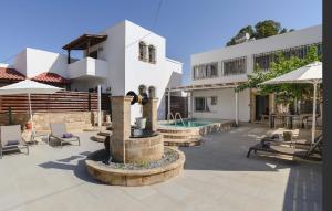 a building with a fountain in the middle of a courtyard at 5 SENSES in Pefki