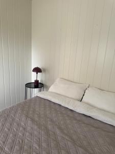 a bedroom with a bed and a table with a lamp at Leilighet midt i sentrum in Kirkenes