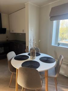 a dining room with a white table and chairs at Leilighet midt i sentrum in Kirkenes