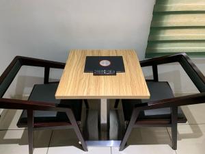 a wooden table with two chairs and a book on it at Trendy Inn limited in Lagos