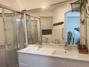 a bathroom with a sink and a large mirror at Private Rm3 with Queen bed in Elderslie