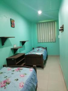two beds in a room with blue walls at Hotel Sicarú in Chapulco