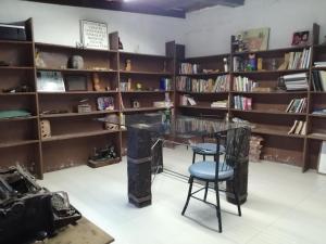 a library with a glass table and a stool at Hotel Sicarú in Chapulco