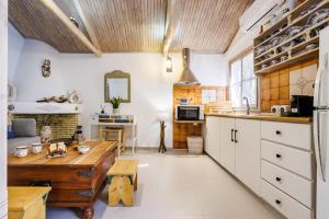 a kitchen with white cabinets and a wooden table at Yianna Cottage Studios in Skopelos Town