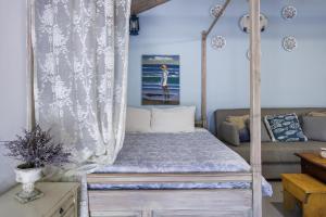 a bedroom with a canopy bed and a couch at Yianna Cottage Studios in Skopelos Town