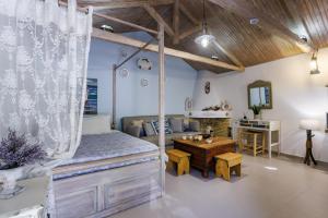 a bedroom with a canopy bed and a desk at Yianna Cottage Studios in Skopelos Town +100 photos