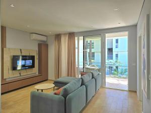 a living room with a couch and a tv at White Shell Apartments in Lalzit Bay