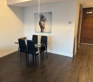 a dining room with a table and chairs and a painting at Brentwood Retreat in Burnaby