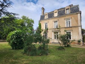 an old house with bushes in front of it at Manoir, vaste parc arboré in Montbron