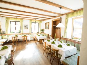 a restaurant with white tables and chairs and windows at Gasthof zur Post in Eberfing