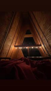 an attic room with a window and a bed at Chalé Refúgio do Lobo in São Bento do Sapucaí