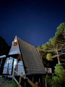 a small house with a roof at night at Chalé Refúgio do Lobo in São Bento do Sapucaí