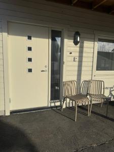 two chairs sitting in front of a garage at Leilighet midt i sentrum in Kirkenes