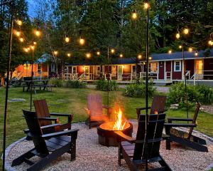 a fire pit in a yard with chairs and a table and afire at The Aurora Inn & Cottages in Bartlett