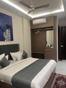 a bedroom with a large white bed and a mirror at Hotel route 54 in Bathinda