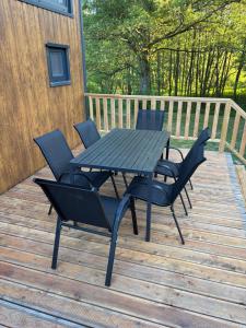 a picnic table and chairs on a deck at Tinyhouse Na Zemi in Žďár nad Sázavou +8 photos