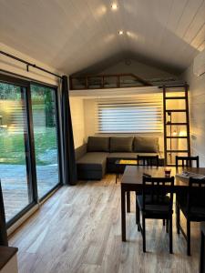 a living room with a couch and a table and chairs at Tinyhouse Na Zemi in Žďár nad Sázavou