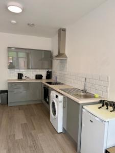 a kitchen with a sink and a washer and dryer at Accessible Town Centre 1 bed Flat Kettering Wi-FI in Kettering