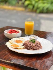 a plate of food with eggs and fruit and a glass of orange juice at Casa Esmeralda Boutique Hotel in San José