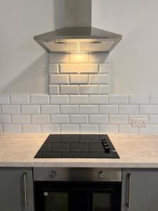 a stove top oven in a kitchen with a hood at Accessible Town Centre 1 bed Flat Kettering Wi-FI in Kettering +7 photos