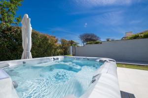 a hot tub in a backyard with an umbrella at Villa Karina - Luxury Suite, Jacuzzi Pool & Garden Ostia Rome in Lido di Ostia +65 photos