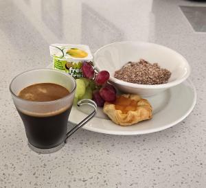 a plate with a cup of coffee and a bowl of food at Art Deco Chic on Queen in Auckland
