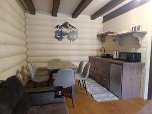 a kitchen with a table and chairs in a room at Тихий світанок in Synevyrsʼka Polyana