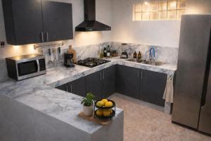 a kitchen with gray cabinets and a sink and a microwave at Hotel Estación del Sol in Las Núñez