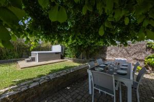 a table and chairs in a garden with a bench at Lividig Bleue en face de la mer in Brignogan-Plage