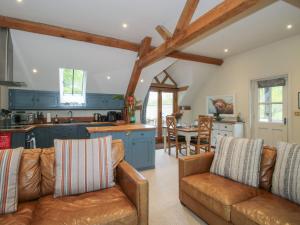 a living room with a couch and a kitchen at Pultheley Cottage in Montgomery