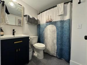 a bathroom with a sink toilet and a shower curtain at Charming 1 bedbath Suite in waterfront Cottage in Somers