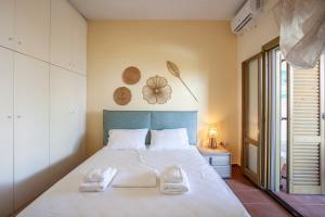 a bedroom with a large bed with two towels on it at Villa Portoblue Pearl in Pefkochori