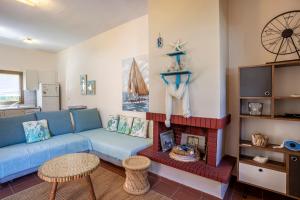 a living room with a blue couch and a fireplace at Villa Portoblue Pearl in Pefkochori