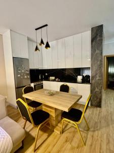 a kitchen with a wooden table and chairs at Your Home Fier 2 in Fier