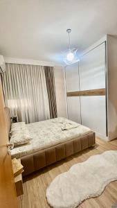 a bedroom with a large bed and a chandelier at Your Home Fier 2 in Fier +6 photos