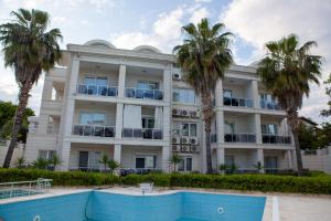 an apartment building with a swimming pool and palm trees at Kemer Suit Residence in Kemer