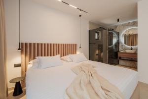a bedroom with a white bed with a blanket on it at Nono Ban Boutique Hotel & Villas in Gornji Humac