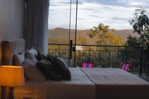 a bedroom with a bed and a balcony with a view at Govinda House in Alto Paraíso de Goiás