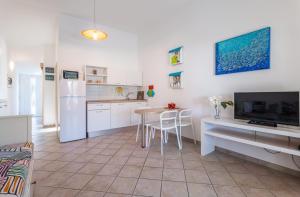 a kitchen with white cabinets and a table and a refrigerator at Apartments Lea in Mandre