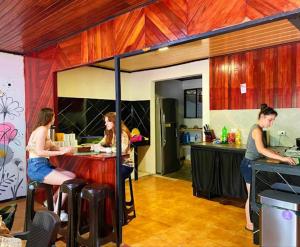 a group of people sitting at a table in a kitchen at Blackout Party Hostel and Experiences in Fortuna