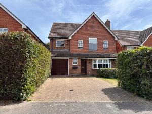 a brick house with a garage in front of it at Spacious 4 Bed Home near Elizabeth Line, great for Contractors, Families, Groups & Insurance stays in Romford