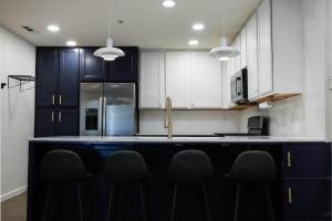 a kitchen with blue cabinets and a counter with chairs at Midnight Modern in San Jose