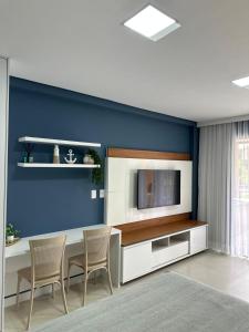 a living room with a table with chairs and a tv at Flat com vista linda Eco Resort in Tamandaré