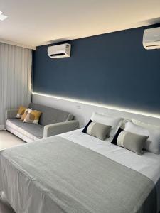 a bedroom with a large bed with a blue wall at Flat com vista linda Eco Resort in Tamandaré +32 photos